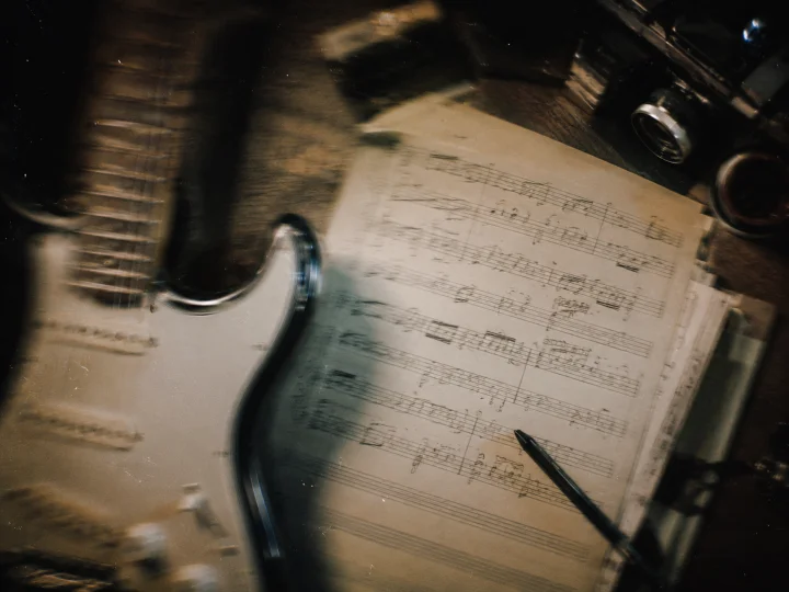 Foto mal sacada de guitarra y partitura